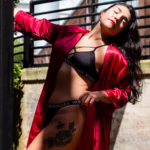 Brunette woman standing outdoors in a robe and lingerie