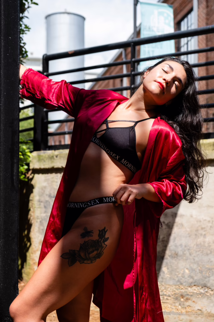 Brunette woman standing outdoors in a robe and lingerie