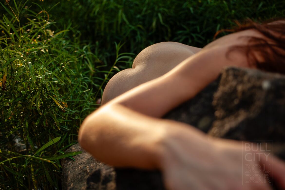 Nude buttocks of a woman durng a boudoir photography session.